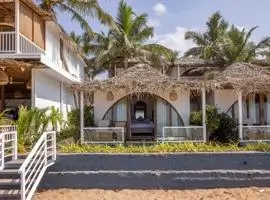 A luxurious beach house with a charming thatched roof and pristine white walls, nestled in a serene coastal setting.