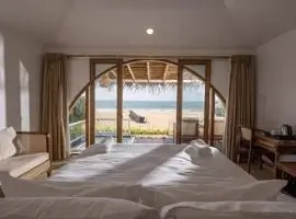 A lavish bedroom overlooking the serene beach and vast ocean, offering a breathtaking view of nature"s beauty.