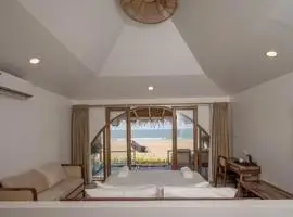 A cozy bedroom with a king-sized bed and a breathtaking beach view. The perfect spot to relax and unwind.