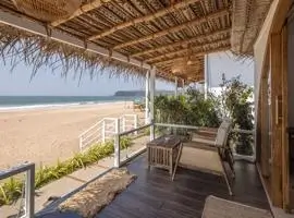 A serene beachfront scene showcasing a wooden deck adorned with elegant table and chairs, inviting relaxation and enjoyment.