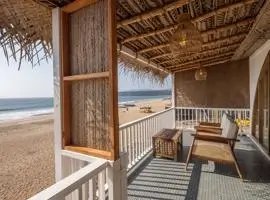 A cozy beach house with a wooden porch, offering breathtaking ocean views. The perfect seaside retreat!