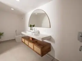 A modern bathroom with a sleek sink and a large mirror reflecting the clean and stylish design.