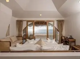 Bedroom with ocean view, featuring a cozy bed, large windows, and calming blue decor.